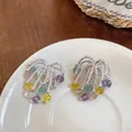 Makroansicht von Silberfeuerwerk-Ohrringen mit bunten Kristallperlen-Quasten auf Teller. - Feuerwerk Form Quaste Stil / Silber Bunt