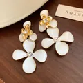 Exquisite close-up detail of vintage white enamel flower drop earrings with crystal centers - 925 Silver Post Style / Gold with White