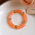 Detailed macro shot of sweet orange marbled acrylic cylindrical bead jewelry piece - Bracelet / Orange