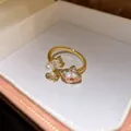 Dettaglio ravvicinato di zircone, perla e cristallo su anello aperto dorato - Anello Aperto a Fiore / Oro-Bianco
