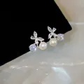 Detailed close-up of 18k gold plated butterfly ear clips with pearls and cubic zirconia - Butterfly Pearl Clip-on Earrings (HE34295) / Silver