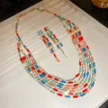Detail view of a retro multi-strand rectangular patchwork necklace and earring jewelry set on tray - Colorful