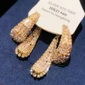 Détail des boucles d'oreilles pendantes à pompons en zircon de style français sur fond bleu - Style Gland Pavé Français (4#)