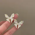 Close-up of elegant enamel butterfly stud earrings with small pearls and crystals. - Silver Post Butterfly Style (HE33833) / Pink