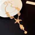 Detailed view of a gold-toned necklace featuring starfish and seashell pendants - Necklace / Gold