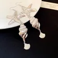 Elegant silver-tone starfish and seashell drop earrings with a high-shine metallic finish - Earring Hooks / Silver