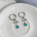 Close-up of zircon moon earrings with teal teardrop gemstone pendants for women. - Moon Waterdrop Pendant Hoop Style / Silver-Blue
