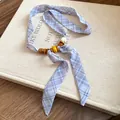 Close-up detail of blue plaid ribbon necklace with colorful polished beads on a book. - Necklace / Blue Plaid