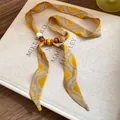 Detailed view of yellow wavy patterned fabric necklace with wooden beads - Necklace / Yellow Wave Pattern