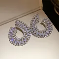 Vue détaillée des boucles d'oreilles géométriques en goutte avec zircons étincelants. - Argent