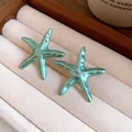 Detailed close-up view of vintage teal starfish earrings featuring a silky metallic finish - Earrings / Teal