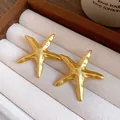 Close-up of elegant gold starfish stud earrings displayed in a luxury jewelry storage box - Earrings / Gold