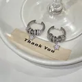 Detail of silver-tone hoop earrings with pavé zircon rings and star charm - Huggie Earrings - Star Pendant Style / Silver