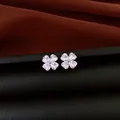 Detailed macro shot of elegant silver stud earrings with heart shaped zircon flower design - Silver-White