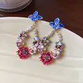 Intricate close-up of elegant floral drop earrings with pearls and 14K gold plating finish - Flower Pendant Style (HE20780) / Multicolor