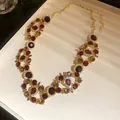 Vista detallada de un collar de estilo vintage con piedras marrones y rojas - Solo Cadena / Café Oscuro