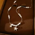 Vue détaillée du collier de perles avec étoile en zircon et breloques de planète sur plateau. - Style Étoile / Argent