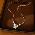 Vue détaillée d'un collier papillon argenté avec perles et zircons en boîte cadeau - Style Papillon / Argent