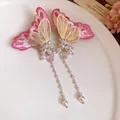 Detailed view of embroidered pink butterfly earrings with pearl tassels and gold accents. - Butterfly Tassel Style / Pink