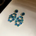 Close-up detail of vintage palace style gold earrings with sparkling blue rhinestones - Earrings Only (Silver Earring Post) / Blue