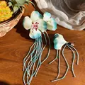 Detailed macro view of pale green fabric flower hair clip with glass bead tassels. - Duckbill Hair Clips / 2 Pcs/Set / Green