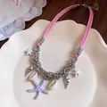 Detailed view of pink leather necklace with starfish and seashell charms on a plate - Silver Pink
