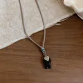 Dettaglio della collana in corda intrecciata con ciondolo a forma di pesce e cuore. - Collana / Nero