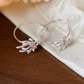Close-up detail of silver hoop earrings with white enamel flower petals and zircons - Flower Hoop (HE31554) / White