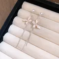 Primo piano di eleganti orecchini a farfalla con nappe rosa e strass scintillanti - Stile Nappa a Farfalla / Rosa