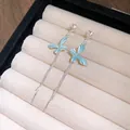 Dettaglio di orecchini a farfalla blu con nappe d'argento e decorazioni in cristallo - Stile Nappa a Farfalla / Blu