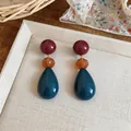 Detailed macro view of colorful resin water drop earrings in a warm lifestyle setting. - Three-Stage Spliced Style (HE32526) / Silver Earring Post-Blue