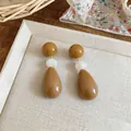 Detailed close-up of stylish brown and white resin waterdrop earrings on a tray - Three-Stage Spliced Style (HE32526) / Silver Earring Post - Coffee