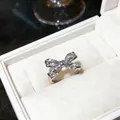 Primer plano macro de un anillo de mariposa plateado con piedras de circón brillante - Estilo Delicado de Lazo Blanco