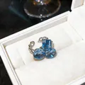 Detalle de un anillo de mariposa con circón azul francés dentro de una caja de regalo - Estilo Mariposa Plata Azul
