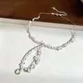 Close-up of heart pendant crystal beaded necklace with iridescent droplets. - Silver-White