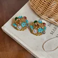 Detailed view of vintage palace-style earrings with turquoise enamel flowers and pearls. - Blue