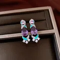 Close-up of vintage drop earrings with purple teardrop stones and turquoise enamel accents - Silver Earring Post Earrings / Silver-Purple