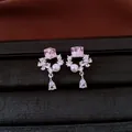 Macro detail of zircon earrings with pink crystal and white pearl in a drop design - Silver Needle / Silver-Pink