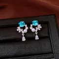 Close-up of elegant stud earrings featuring blue crystal cubes and pearl accents - Silver Needle / Silver-Blue