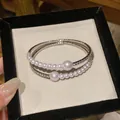 Close-up of elegant double-strand bracelet with pearls and rhinestones in display box - Silver/White