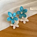 Detailed close-up of blue and white enamel flower earrings with sparkling rhinestones - Double Layer Flower / Blue