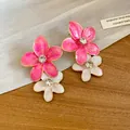 Close-up detail of stylish pink and white enamel flower earrings with central rhinestones - Double Layer Flower / Pink