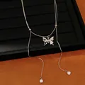 Detail view of dainty silver butterfly necklace with elegant white pearl tassel drops - Silver