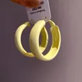 Detailed view of bright yellow painted hoop earrings with minimalist circular design - Large / Yellow