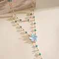 Macro view of blue resin flower and crystal charms on a layered gold-tone necklace - Blue Floral (Double Layered) / Gold