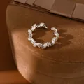 Gros plan d'une bague torsadée argentée ornée de zircons cubiques étincelants - Enroulement Tordu (HR3526) / Argent