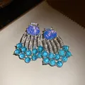 Close-up of vintage luxury blue resin earrings with rhinestone tassels and bead fringe - Vintage Tassel Style / Silver Earring Post - Silver - Blue