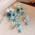 Vue détaillée de boucles d'oreilles fleurs en tissu avec dégradé bleu et vert et glands - Vert
