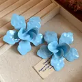 Primer plano del acabado de esmalte azul claro mate de estos pendientes de flores. - Azul