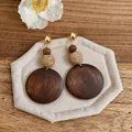 Detailed view of ethnic round dark wood drop earrings with woven beads and gold studs - Round Pendant Style (HE32731) / Brown